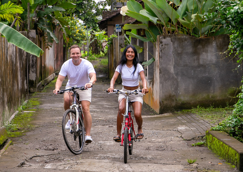 Man and woman cycling in the streets of Tembi Village